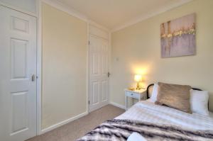a bedroom with a bed and a lamp on a table at Hampson House Stevenage by PAY AS U STAY in Stevenage