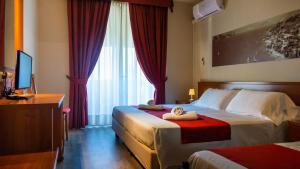 a hotel room with two beds and a television at Hotel Venezia Park - ENJOY HOLIDAY in Colà di Lazise