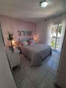 コニル・デ・ラ・フロンテーラにあるAtalaya a pie de playaのベッドルーム1室(ベッド1台、テーブル、窓付)