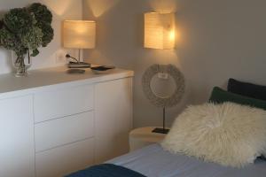 a bedroom with a bed with a white blanket and two lamps at Le Clos d'Estellan - Piscine chauffée in Bonnieux