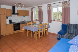 cocina y sala de estar con mesa y sillas en Ferienhof Lecheler, en Breitenthal