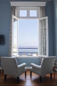 a living room with a window with a view of the ocean at Zero Hotel in Valparaíso