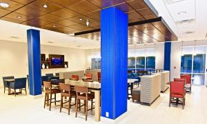 um restaurante com colunas azuis, mesas e cadeiras em Holiday Inn Express & Suites - Perryville I-55, an IHG Hotel em Perryville