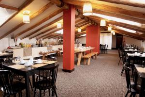 a restaurant with tables and chairs in a room with wooden ceilings at Abittare Hotel in Cusco