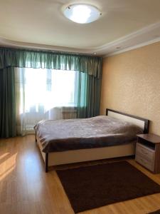 アバカンにあるApart-Hotel Mirkvartirのベッドルーム1室(ベッド1台、大きな窓付)