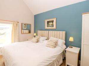a bedroom with a large white bed with blue walls at Riding Farm in Gateshead +97 photos