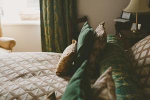 a bedroom with a bed with pillows on it at Riding Farm in Gateshead