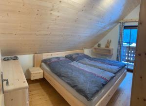a bed in a room with a wooden ceiling at Almhaus & Almchalet Flattnitz in Flattnitz