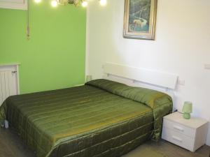 a green bedroom with a bed and a picture on the wall at Bed and Breakfast lo Scrigno in Polinago +14 photos
