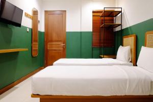 Uma cama ou camas num quarto em Liberta Malioboro South