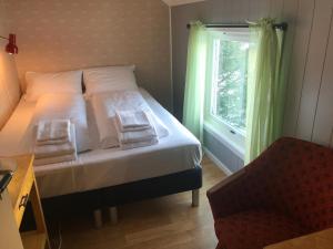 a bedroom with a bed and a window with green curtains at Lofoten Hillside Lodge in Alstad