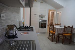 uma cozinha com um balcão, uma mesa e um fogão em B&b In Piazza - San Gemini - Umbria em San Gemini