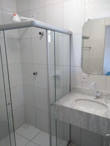 a white bathroom with a sink and a mirror at Lamares Pousada de Charme in Santa Cruz Cabrália