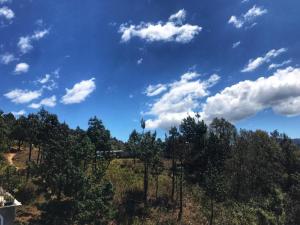 a blue sky with clouds and trees on a hill at Hostal mandala Evelyn in El Pacífico