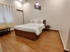 1 dormitorio con 1 cama grande y suelo de madera en Hotel Surya Grande, en Kudāl