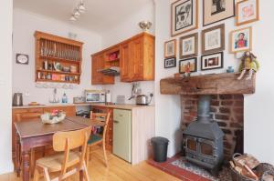 a kitchen with a fireplace and a table and a stove at Cozy with Character Vibrant Cottage Style Flat at Leith Links Park in Edinburgh