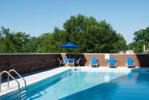 a pool with a blue chair and blue umbrellas at Holiday Inn Arlington at Ballston, an IHG Hotel in Arlington