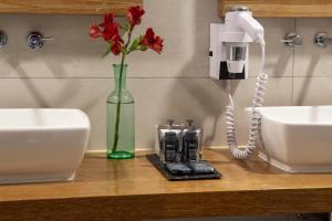 a vase with red flowers on a counter with a phone at Abittare Hotel in Cusco