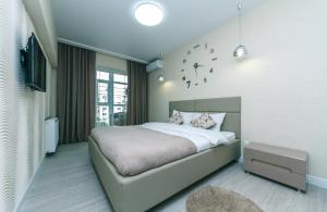 a bedroom with a large bed and a tv at Pechersky Kvartal Apartments in Kyiv