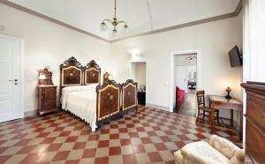 a bedroom with a bed and a checkered floor at Epoca - Camere con stile in Ragusa