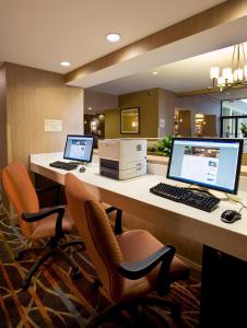 un bureau avec deux ordinateurs sur un bureau et des chaises dans l'établissement Holiday Inn Gaithersburg, an IHG Hotel, à Gaithersburg