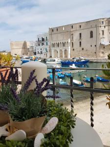 a balcony with a view of a harbor with boats at Palazzo Venezia - Luxury holiday rooms in Monopoli