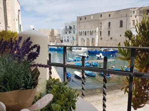 a balcony with a view of the water and boats at Palazzo Venezia - Luxury holiday rooms in Monopoli