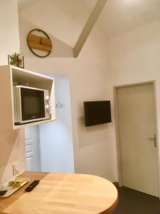 a room with a table and a tv on the wall at Sémard in Brive-la-Gaillarde