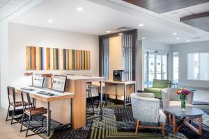 a living room with a desk and chairs and a kitchen at Holiday Inn Express & Suites - Punta Gorda, an IHG Hotel in Punta Gorda