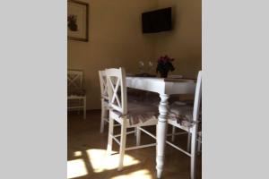 uma sala de jantar com uma mesa branca e cadeiras em Charming Family Lodge With Private Garage em Florença