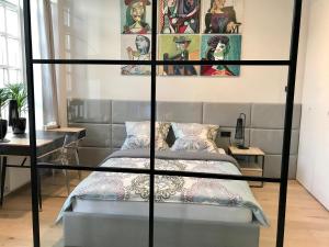 ein Schlafzimmer mit einem Bett und Plakaten an der Wand in der Unterkunft Neon Loft Apartament Bukowskiego in Białystok