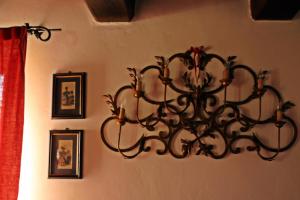 a black chandelier hanging on a wall with pictures at Agriturismo Il Barco in Spello
