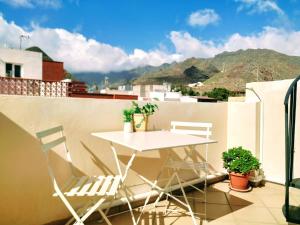 a balcony with a table and chairs on a roof at Apt. Lourdes, close to the Teresitas & Anaga in El Roque