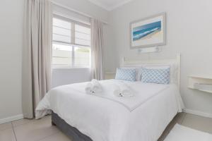 a bedroom with a large white bed with towels on it at South Point Guest Lodge in Agulhas