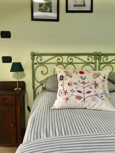 a bed with a white pillow with a tree design on it at Cascina Bertolotto Wine Resort in Spigno Monferrato