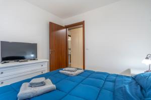 una camera con letto blu e TV di Moderno Appartamento Tarvisio - A due passi dalla Ciclovia! a Tarvisio