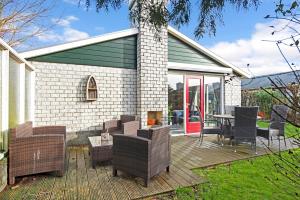 a wooden deck with chairs and a table and a house at Ferienhaus Petten aan Zee in Petten