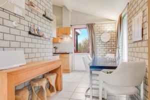 a kitchen with a blue table and white chairs at Ferienhaus Petten aan Zee in Petten