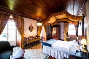 une chambre avec un lit à baldaquin et un canapé dans l'établissement Casa Nobre do Correio-Mor, à Ponte da Barca 25 autres photos