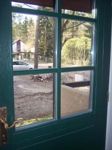 a door with a window looking out at a yard at Apartement in Siedlung Schönwalde