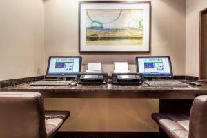 拉瓦勒的住宿－拉瓦爾蒙特利爾假日酒店，一张桌子,上面有三台笔记本电脑