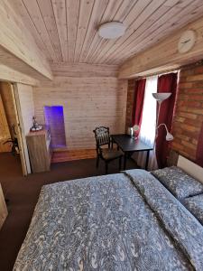 ein Schlafzimmer mit einem Bett und einem Tisch mit einem Stuhl in der Unterkunft Kambarių nuoma Salantuose in Salantai