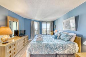 een blauwe slaapkamer met een bed en een televisie bij Summer House 309 in Isle of Palms