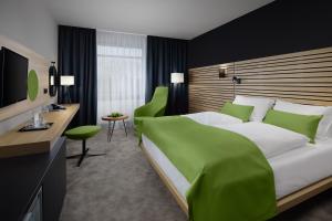 ポジェブラディにあるSpa Hotel Felicitasのベッドルーム(緑色の大型ベッド1台、デスク付)