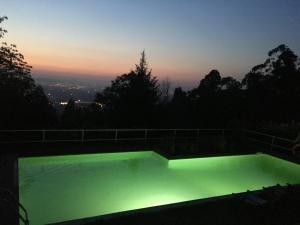 una piscina con un resplandor verde por la noche en Quinta das Leiras en Santo Tirso