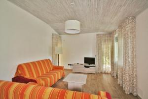 un soggiorno con divano e tavolo di BA - VILLA LUCY - Single Villa - a Lignano Sabbiadoro