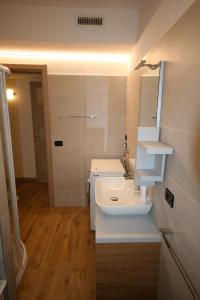 uma casa de banho com um lavatório branco e um espelho. em BA - VILLA LUCY - Single Villa - em Lignano Sabbiadoro