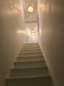 uma escada com dois lustres e algumas escadas em La petite Noe em Vertou