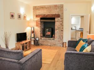 a living room with two couches and a fireplace at 6 The Grove in Telford