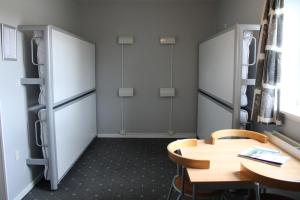 Zimmer mit einem Tisch und einem Kühlschrank in der Unterkunft Hostel Herning in Herning